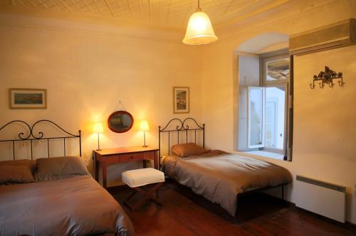 a bedroom with two beds and a window at Hydra Optima in Hydra