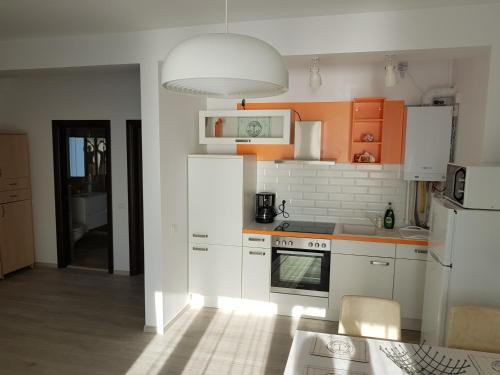 ママイア・ノルドにあるBiandada Apartmentsのキッチン(白い家電製品、オレンジ色のキャビネット付)