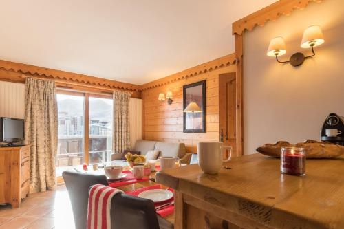 une cuisine et un salon avec une table et une salle à manger dans l'établissement Résidence Pierre & Vacances Premium Les Hauts Bois, à Aime La Plagne