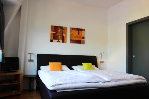 - une chambre dotée d'un lit avec des oreillers colorés dans l'établissement Pension Adelheid Moselhype&Wine, à Zell