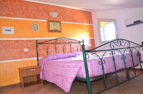 een slaapkamer met een bed met een roze dekbed bij Paradise Beach camera mansardata vicino Cefalù PISCINA APERTA in Campofelice di Roccella