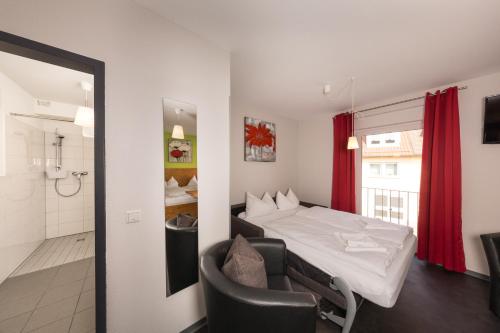 a hotel room with a bed and a bathroom at Hotel Demling in Randersacker