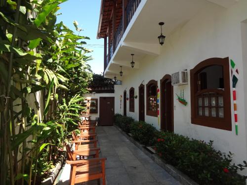 a courtyard of a house with wooden benches at Pousada Doce Paraty in Paraty