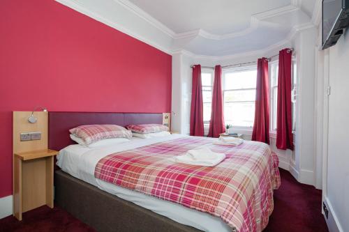 a bedroom with a red bedspread and a white bedspread at Regent House Hotel - City Centre Hotel in Edinburgh