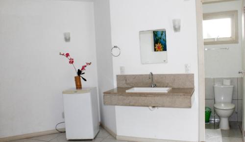 a white bathroom with a sink and a toilet at Deck de Búzios in Búzios