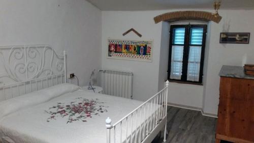 カルミニャーノにあるAgriturismo Frigionaiaのベッドルーム1室(花が咲く白いベッド1台付)