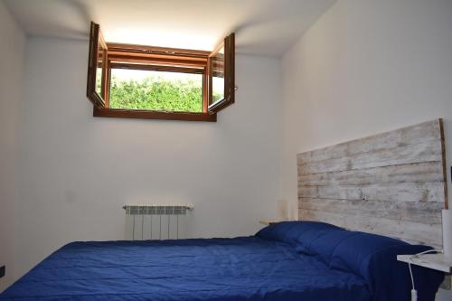 a bedroom with a blue bed and a window at Sofia Mare in San Felice Circeo
