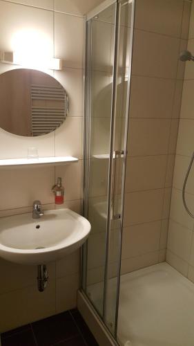 W łazience znajduje się umywalka i prysznic. w obiekcie Am Alten Hafen w mieście Neuharlingersiel