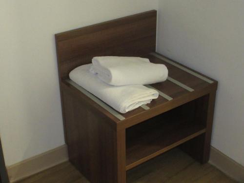 a shelf with three folded towels on it at Hôtel le Pastel in Toulouse