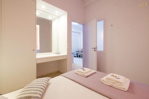 a bedroom with two towels on a bed in front of a mirror at Cozy Home steps from old Port, Seafront & Parking in Kolymvari