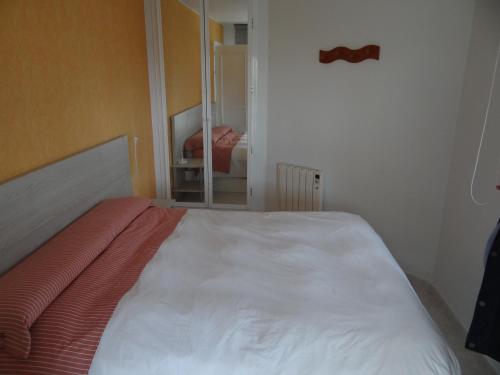 um quarto com uma cama com uma gravata borboleta na parede em Apartamento en Vinaros em Vinarós