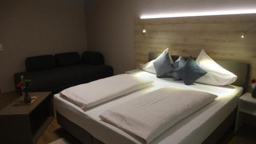 a bedroom with a large bed with white sheets and pillows at Seegasthof Breineder - Familien & Seminarhotel in Mönichwald