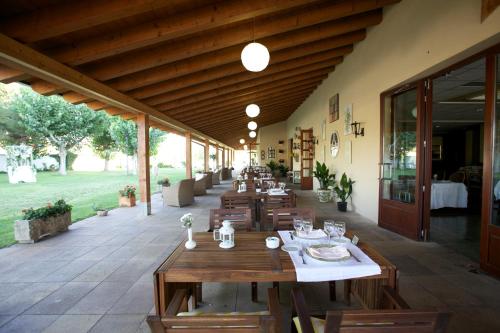 um restaurante com mesas e cadeiras de madeira num pátio em Hotel del Carme em Vilagrasa