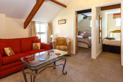 uma sala de estar com um sofá vermelho e uma mesa em The Hay Loft em Sedgefield