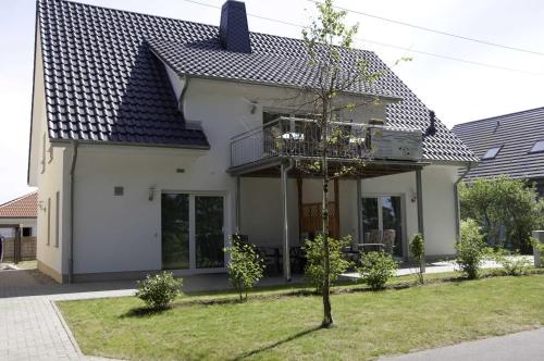 ツィノヴィッツにあるHaus Werder Wohnung 2 mit Kaminの白家の前の小木