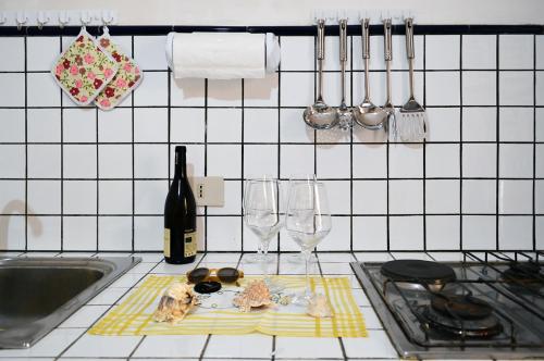 eine Küchentheke mit Weingläsern und einem Teller mit Lebensmitteln in der Unterkunft Don Vito's Apartments in Castellammare del Golfo