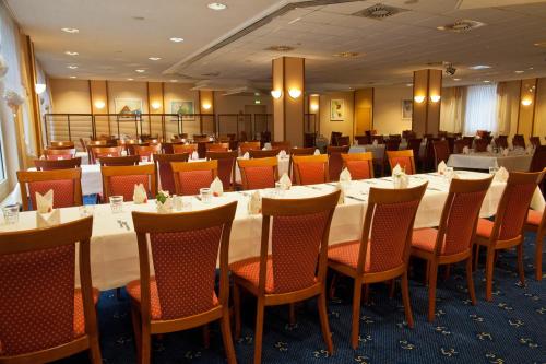 a conference room with a long table and chairs at NOVINA HOTEL Südwestpark in Nürnberg