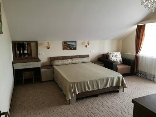 a bedroom with a bed and a chair and a mirror at Vila Teju Valeni in Vălenii de Munte