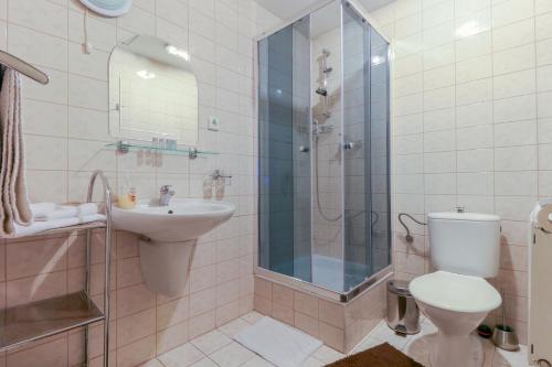 een badkamer met een douche, een toilet en een wastafel bij Penzión Grand in Trnava