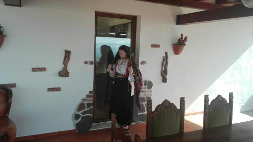 a woman standing in front of a wall with some figurines at B&B Bella Vista in Dorgali