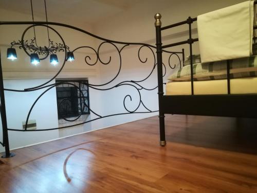 a bedroom with a wrought iron bed and a table at Apartman Galerija in Novi Sad