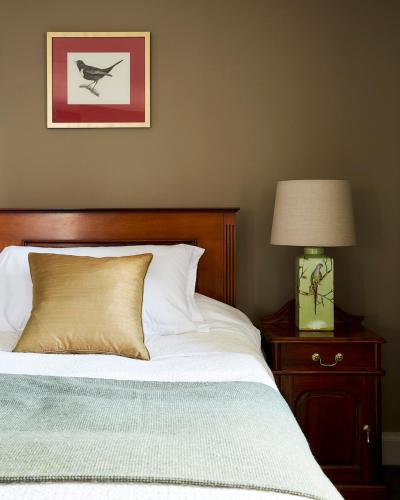 a bed with a pillow and a lamp on a night stand at Kinloch Lodge Hotel and Restaurant in Kinloch