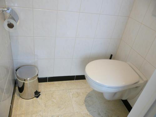 a bathroom with a toilet and a trash can at De Windroos in Pollinkhove