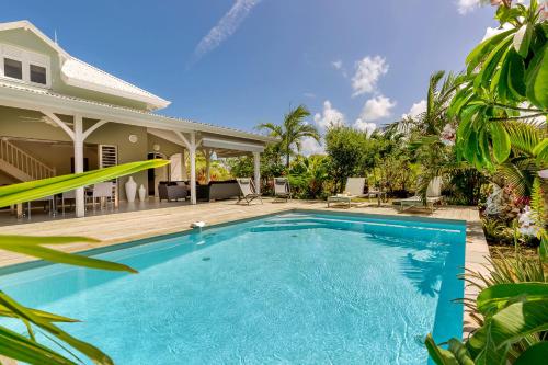 a swimming pool in front of a house at Villas Palm in Le Vauclin