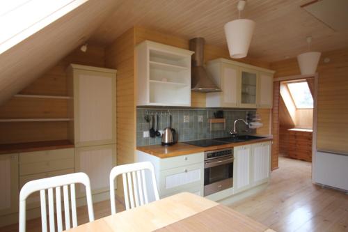 a kitchen with white cabinets and a table with chairs at Ranna puhkemaja in Lemsi