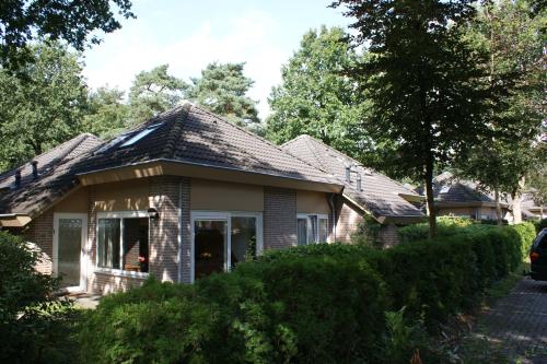a house with a shingled roof at Bungalow 6 personen in Nunspeet