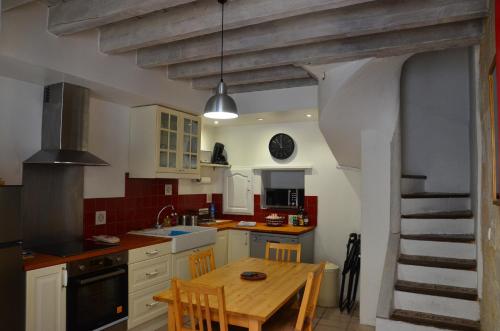 une cuisine avec une table en bois et une salle à manger dans l'établissement la pitchoun des Arènes, à Arles