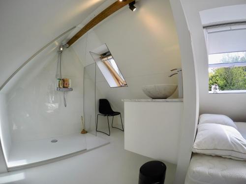 um quarto branco com um lavatório e uma cama em Chaleureux em Wenduine