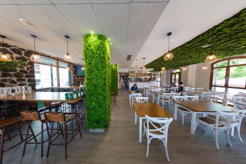 un restaurante con mesas y sillas y una pared verde en Hotel Boutique Bahía de Plentzia, en Plentzia