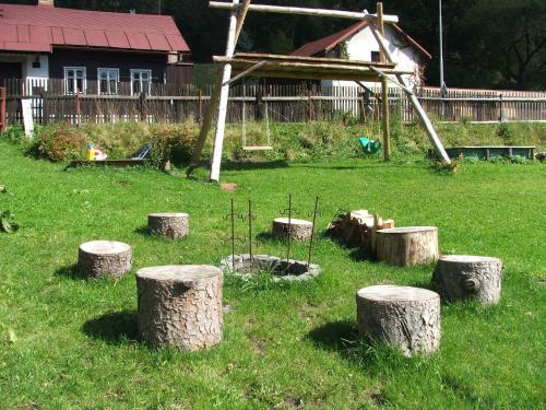 a group of tree stumps in the grass with a park at Ala ubytovani in Josefuv dul