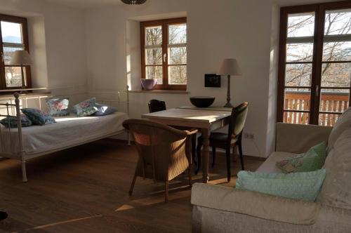 a living room with a table and a couch at Malerhaus am Kolbergarten in Bad Tölz