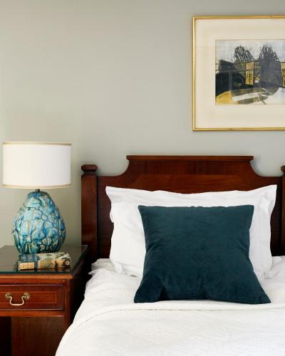 a bedroom with a bed with a green pillow and a lamp at Kinloch Lodge Hotel and Restaurant in Kinloch
