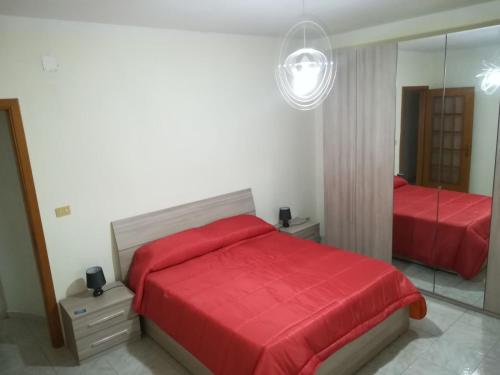 シラクーサにあるLa casa di Evaのベッドルーム(赤いベッド1台、鏡付)