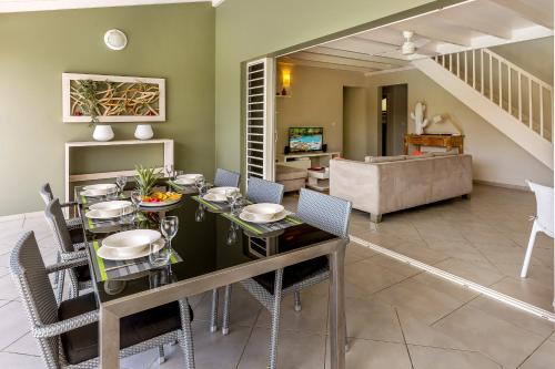 a dining room and living room with a table and chairs at Villas Palm in Le Vauclin