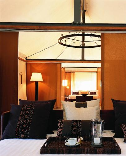 a hotel room with a bed with a tray on it at Kirimaya Golf Resort Spa - SHA Plus Certified in Mu Si