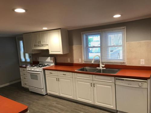 a kitchen with white cabinets and a sink at Wildwood Inn Hotel Travelodge Beach & Boardwalk in Wildwood