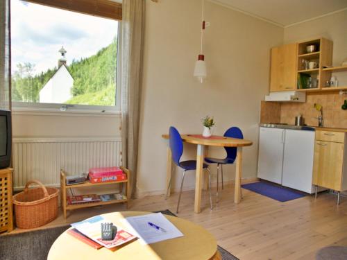 a living room with a table and a kitchen at Prästgården i Funäsdalen in Funäsdalen