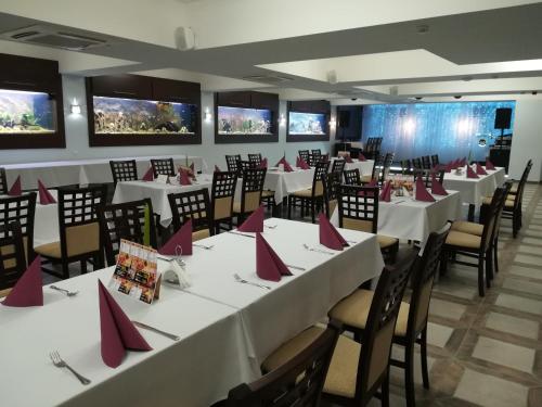 uma sala de jantar com mesas e cadeiras com guardanapos vermelhos em Hotel Elizabeth em Baja