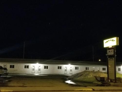 a white building with a sign in front of it at night at Melsask Motel in Melville