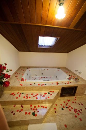 a room with a bath tub with red flowers on the floor at Pousada Vollweiter in Entre Rios