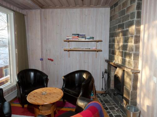 a living room with two chairs and a table and a fireplace at Prästgården i Funäsdalen in Funäsdalen