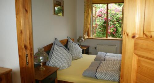 a bedroom with a bed with pillows and a window at Fördefarm-Natura in Westerholz