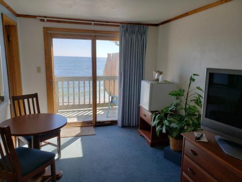 a living room with a television and a view of the ocean at Algoma Beach Motel in Algoma