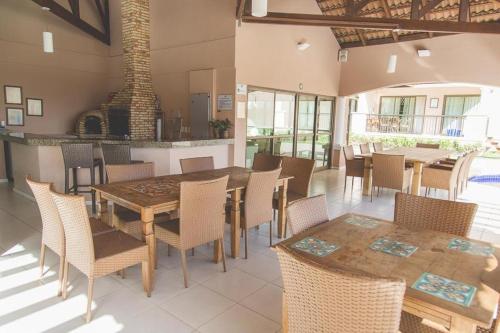 ein Esszimmer mit Tischen und Stühlen und einem Kamin in der Unterkunft Cobertura Duplex Beverly Hills in Aquiraz