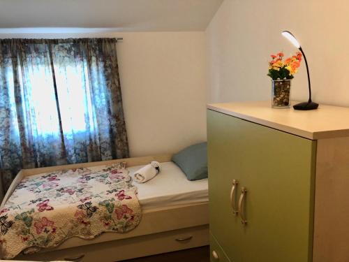 a bedroom with a bed with a dresser and a window at Apartment Jopa in Šibenik