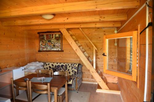 a dining room in a log cabin with a table and chairs at Motel Krstac in Mojkovac